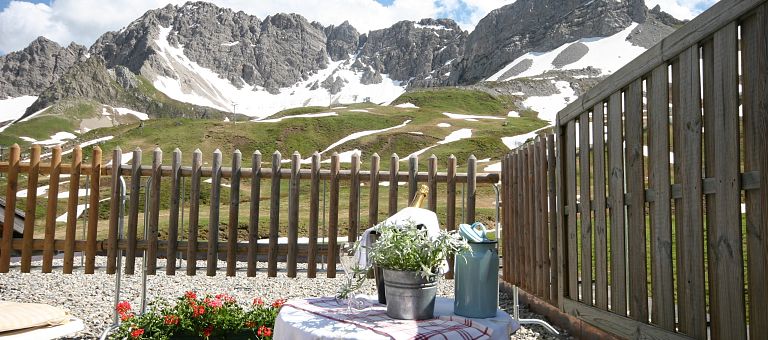 Bei schneebedeckte Bergspitzen auf der Hochalp Hütte feiern