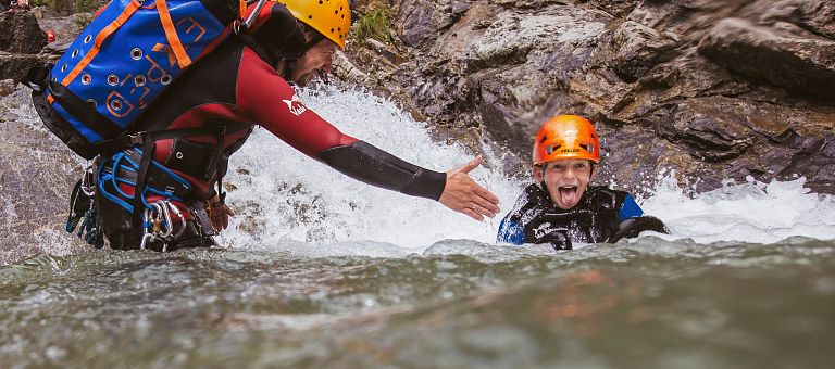 Gemeinsames Zusammenhelfen beim Canyoning nahe dem Hotel Jägeralpe