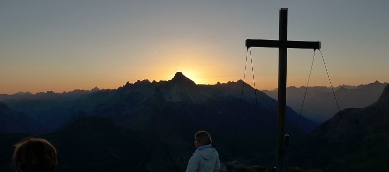 Malerischer Sonnenuntergang am Gipfelkreuz vom Geishorn in Warth am Arlberg